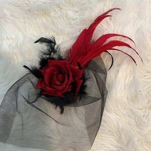 Fascinator hat with beautiful red feathers and red rose. Black net face cover.